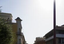 스트레스, 일상 속 작은 변화로 관리하세요 A woman walking down a street next to tall buildings