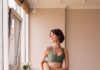 바쁜 일상 속 ‘필라테스’, 건강과 마음을 다잡는 새로운 습관 a woman in a green sports bra top and leggings holding a yoga mat