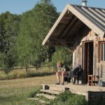 “마음 건강을 위한 ‘디지털 디톡스’…쉽게 시작하는 일상 리셋법” Man sitting on rustic cabin porch in nature.