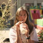‘마음챙김 식사’ 실천, 건강한 일상으로의 작은 출발 Woman sips a drink on a sunny outdoor patio